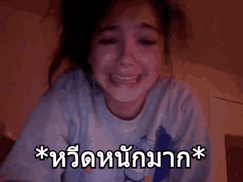 a woman is crying in front of a camera with a foreign language written on it .
