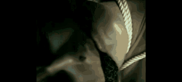 a man with a tattoo on his arm is standing in a dark room .