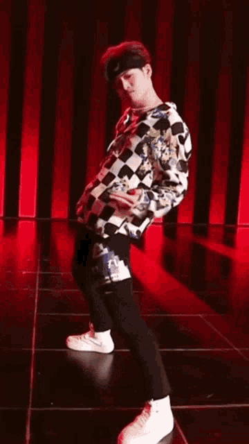 a man wearing a headband and a checkered shirt is dancing