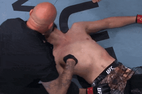 a man is laying on the ground with a ufc shorts on
