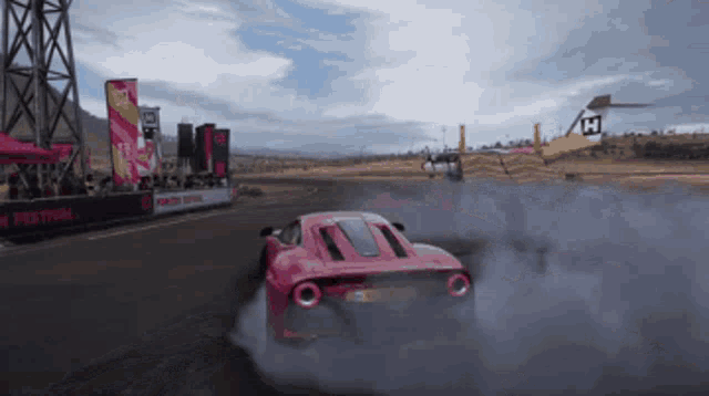 a pink car is drifting on a race track with a sign that says horizon festival in the background