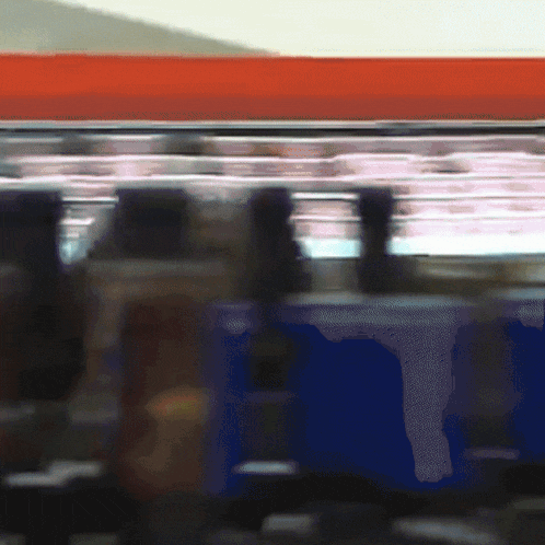 a blurry picture of a red and blue train with a red roof