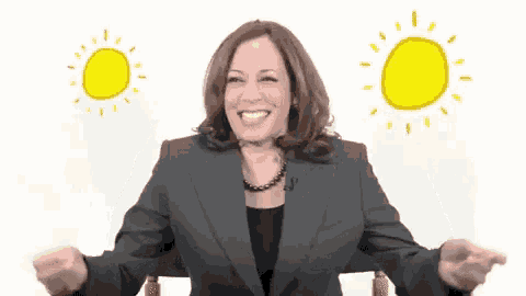 a woman in a suit is smiling with two yellow suns behind her