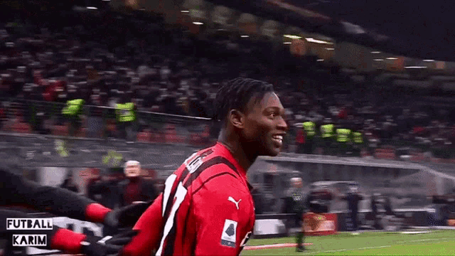 a soccer player in a red jersey with fly emirates on the front