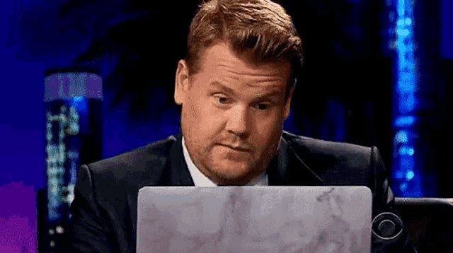 a man is sitting in front of a laptop computer .