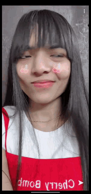 a girl with a cherry on her face is wearing a red dress