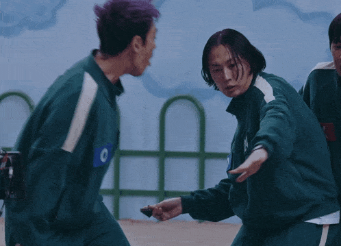a man with purple hair is fighting another man in a green uniform with the number 4 on it