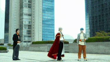 a man in a red cape stands in front of a building