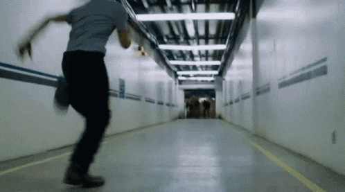 a man is running through a tunnel with a yellow line on the floor