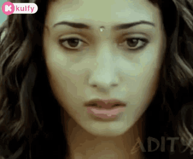 a close up of a woman 's face with the word kulfy on the bottom