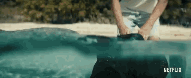 a man is standing in the water with a netflix logo behind him