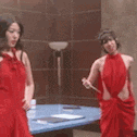 a woman in a red dress is standing in front of a mirror .