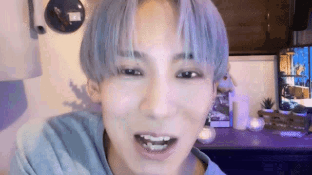 a close up of a person 's face with a blue haircut .