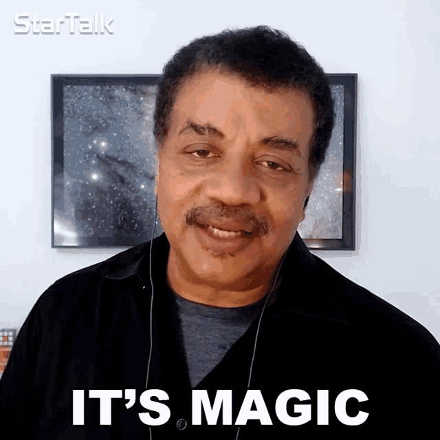 a man with headphones says it 's magic in front of a framed picture