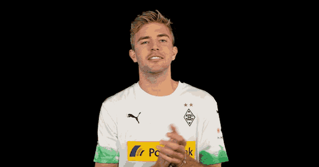 a man wearing a white and green postba shirt