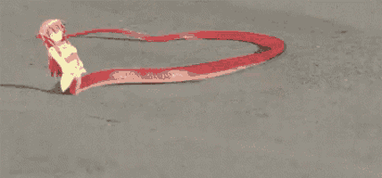 a red snake is crawling on a concrete surface with a yellow object in its mouth