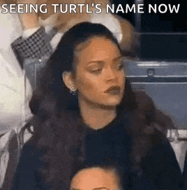 a woman is sitting in a stadium watching a game and looking at something .