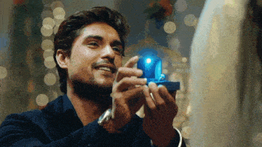 a man holding a blue box with a light inside