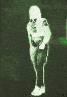 a green and white image of a person standing in the dark