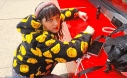 a girl wearing a black and yellow jacket with smiley faces