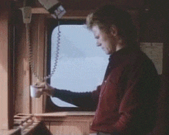 a person standing in front of a window with a phone hanging from it
