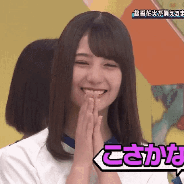 a girl is smiling with her hands folded in front of a sign that says " cs "