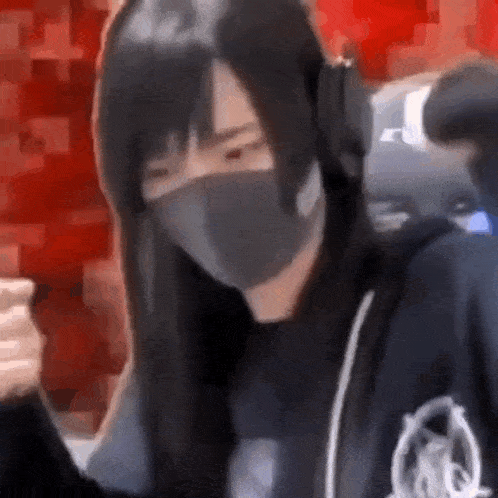 a woman wearing a mask and headphones is sitting in a chair .