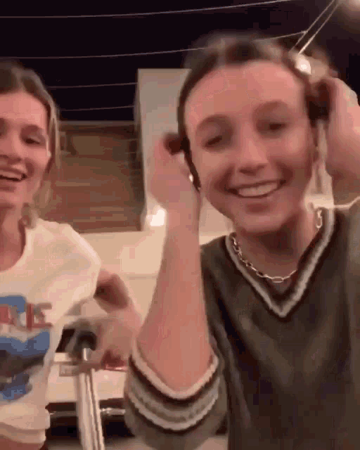 a couple of women are standing next to each other and smiling .