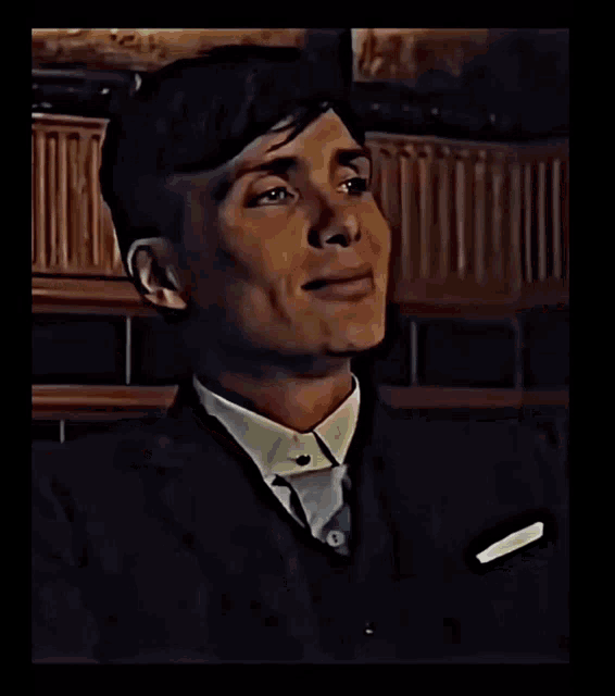 a man in a suit and tie is smiling and looking at the camera