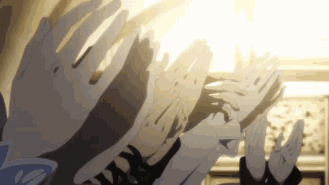 a group of people are holding their hands in the air
