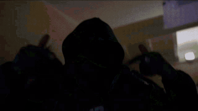 a man wearing a hooded jacket and a hoodie that says ' hood gang ' on it