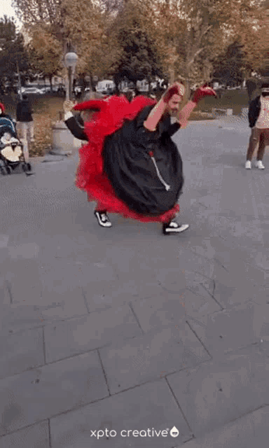 a person in a red dress is doing a handstand on a bench with xpto creative in the corner