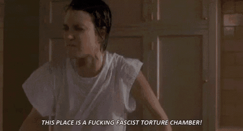 a woman in a white shirt is sitting in a chair in a room and screaming .