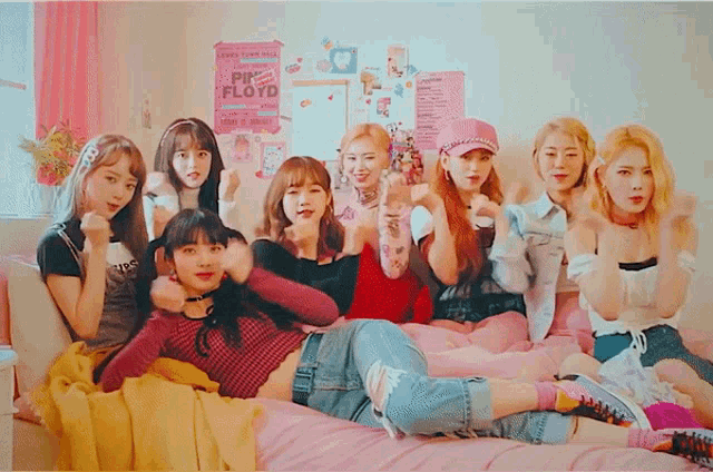 a pink floyd poster hangs on the wall above a group of girls
