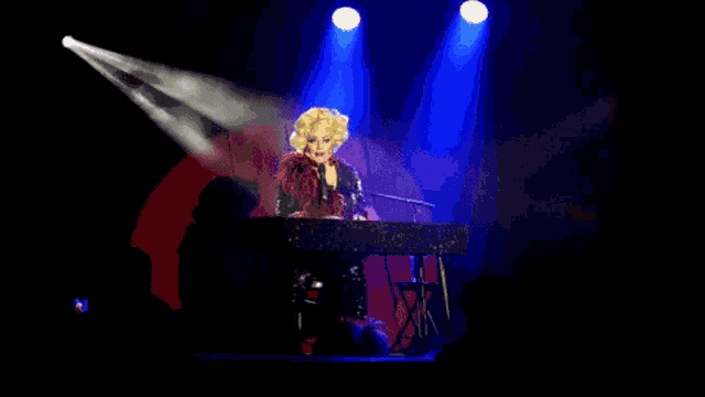 a blonde woman singing into a microphone while playing a piano