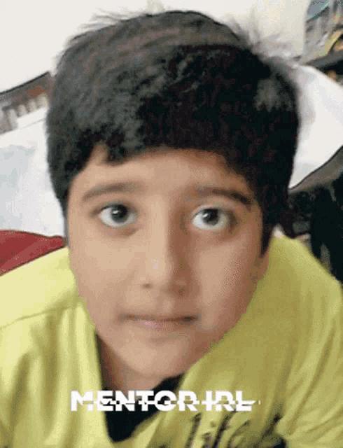 a young boy wearing a yellow shirt with the word mentor on it