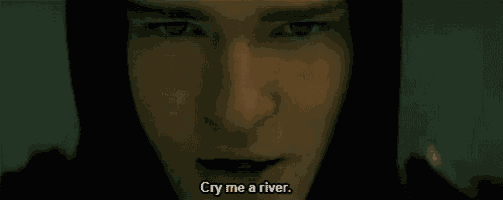 a close up of a man 's face with the words cry me a river written below him .