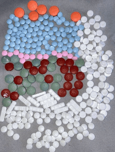 a bunch of different colored pills with one that says 00