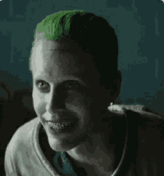the joker from the movie suicide squad is smiling and looking at the camera .