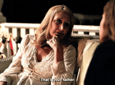 a woman sitting on a couch talking to another woman and says " that 's your father "