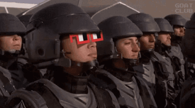 a group of soldiers are standing in a row wearing helmets and glasses .