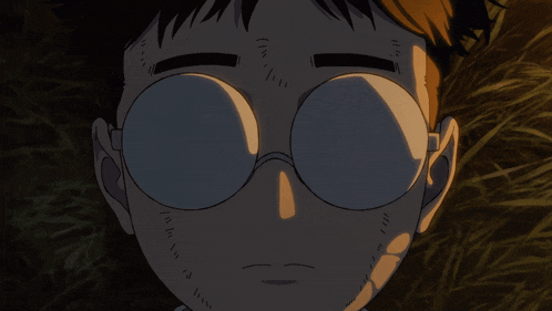 a close up of a person 's face with round glasses on