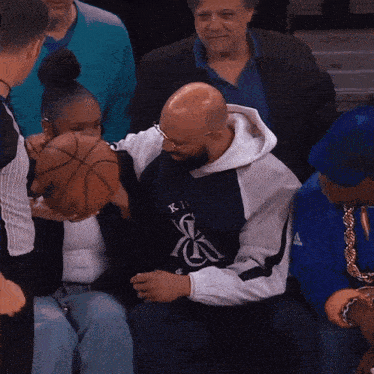 a man holding a basketball while wearing a shirt that says ' x ' on it