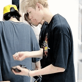 a man in a black shirt is holding a cell phone in his right hand