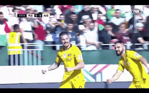 two soccer players are celebrating a goal during a fox sports broadcast