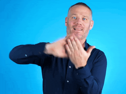 a man in a blue shirt is clapping his hands against a blue background