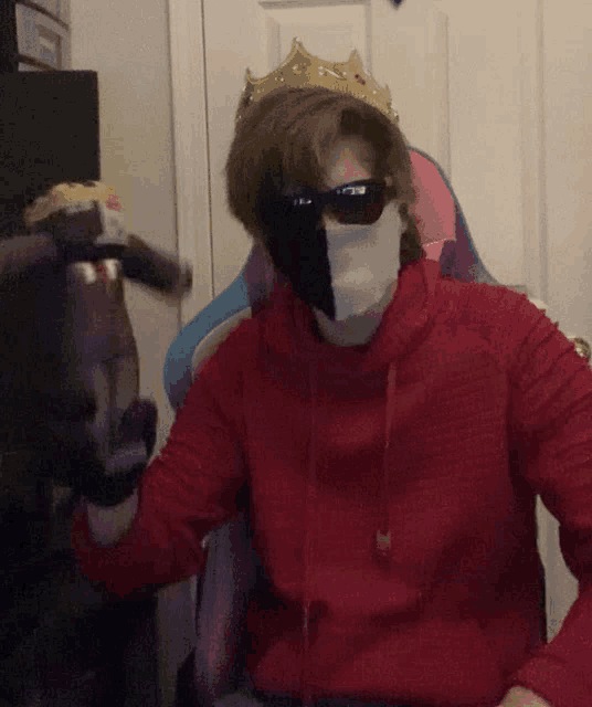 a man wearing a red hoodie and a black and white mask