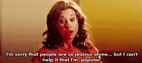 a woman in an orange shirt is saying i 'm sorry that people are so jealous of me