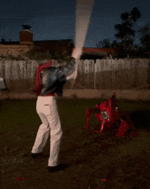 a man with a blindfold is holding a large wooden paddle