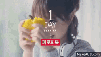 a woman is eating a yellow pepper with the words 1 day paprika on the bottom